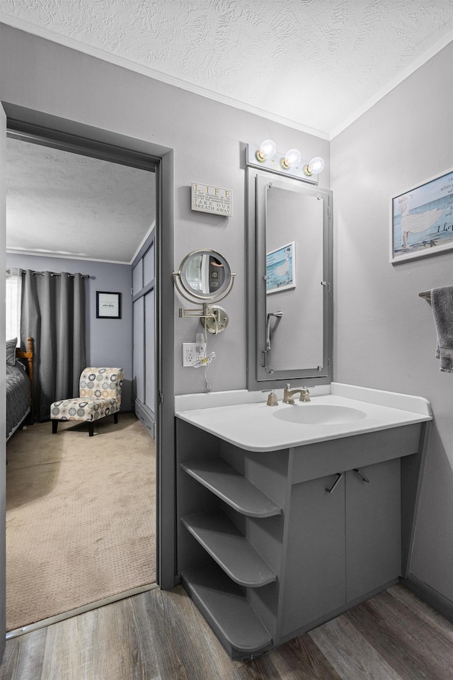 4511 E Eden St, Lincoln, NE 68506 - bathroom with a textured ceiling, ornamental molding, vanity, and wood finished floors