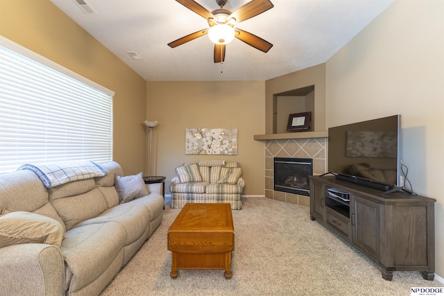 living area featuring ceiling fan, light carpet, a fireplace, and baseboards