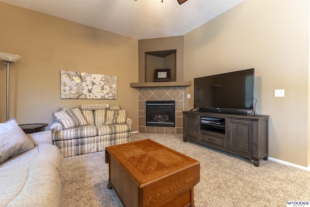 living area with light carpet, a ceiling fan, a fireplace, and baseboards