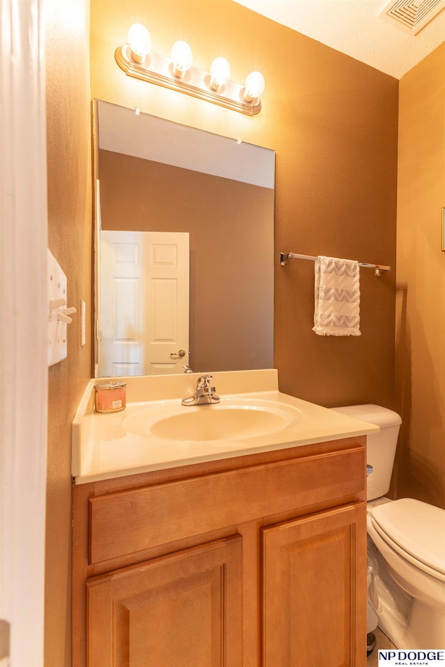 bathroom featuring toilet and vanity