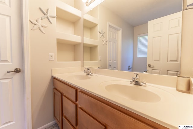 bathroom with double vanity and baseboards