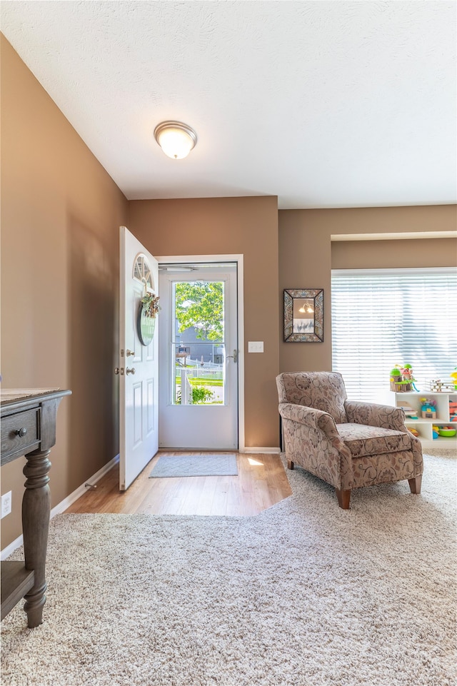 foyer featuring wood finished floors and baseboards