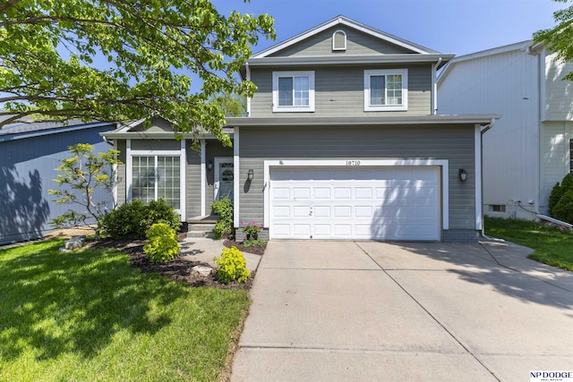traditional home featuring concrete driveway, a garage, and a front lawn
