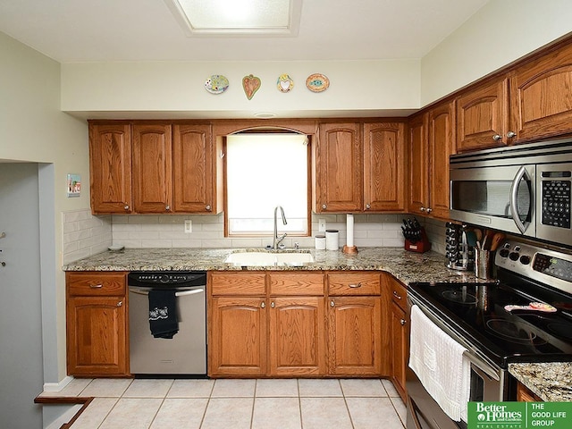 14824 Charles Plz, Omaha, NE 68154 - kitchen featuring appliances with stainless steel finishes, a sink, light stone counters, and brown cabinets
