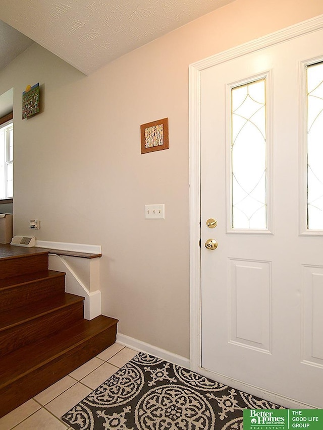14824 Charles Plz, Omaha, NE 68154 - entrance foyer featuring plenty of natural light, stairs, light tile patterned floors, and baseboards