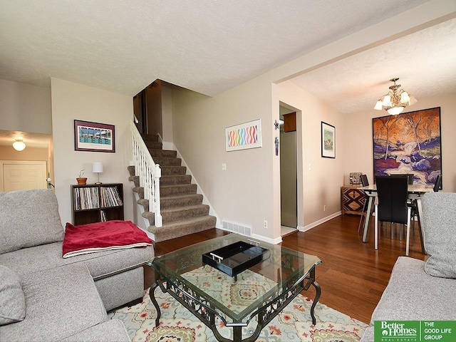 14824 Charles Plz, Omaha, NE 68154 - living room with wood finished floors, stairway, a chandelier, baseboards, and a textured ceiling