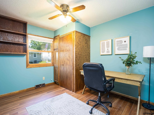 office space with ceiling fan, wood finished floors, a textured ceiling, and baseboards