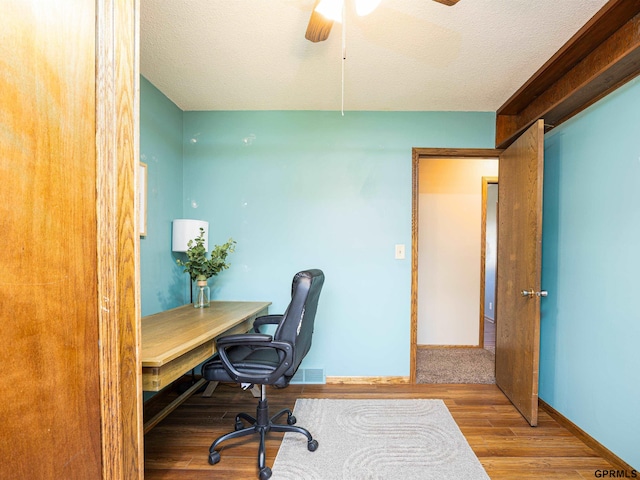 office space featuring a ceiling fan, wood finished floors, baseboards, and a textured ceiling