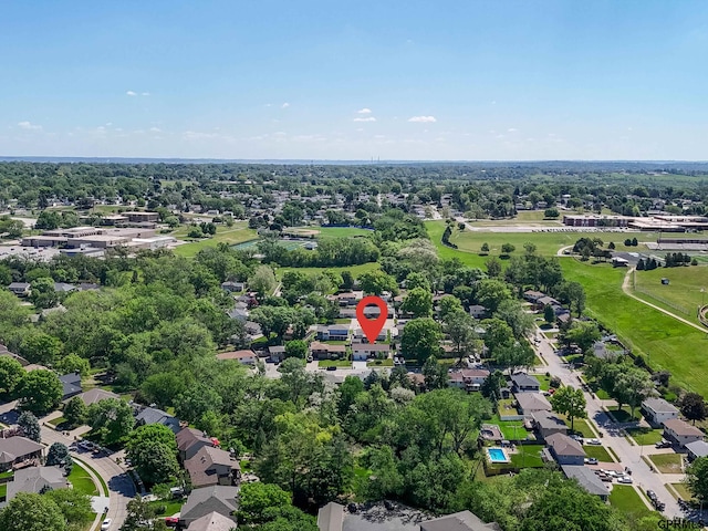 aerial overview of property's location with nearby suburban area and a tree filled landscape