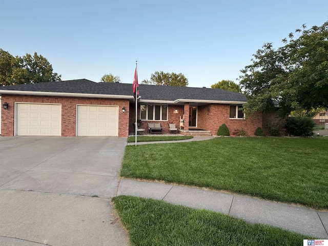 1714 S 14th Circle Dr, Beatrice, NE 68310 - ranch-style home with an attached garage, concrete driveway, a front lawn, and brick siding