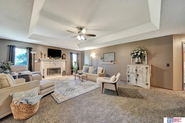 1714 S 14th Circle Dr, Beatrice, NE 68310 - living area featuring a raised ceiling, ceiling fan, a tile fireplace, carpet floors, and baseboards