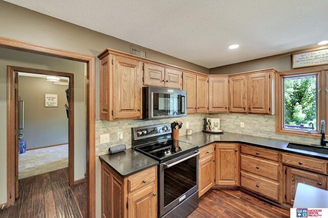 1714 S 14th Circle Dr, Beatrice, NE 68310 - kitchen with electric range, a sink, dark countertops, dark wood-style floors, and decorative backsplash