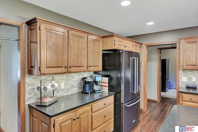 1714 S 14th Circle Dr, Beatrice, NE 68310 - kitchen with high quality fridge, dark countertops, dark wood finished floors, decorative backsplash, and baseboards