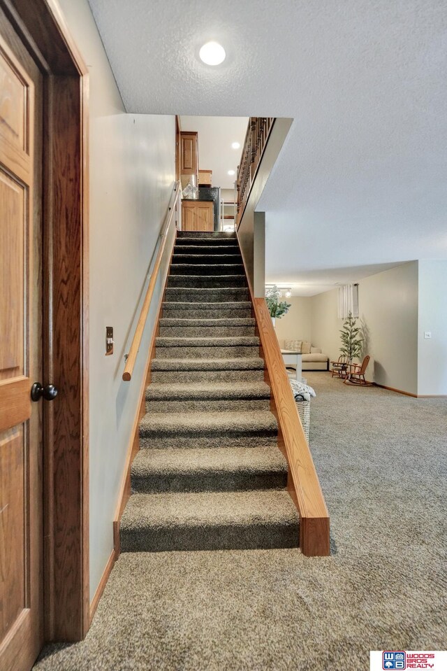 1714 S 14th Circle Dr, Beatrice, NE 68310 - staircase with carpet flooring, a textured ceiling, baseboards, and recessed lighting