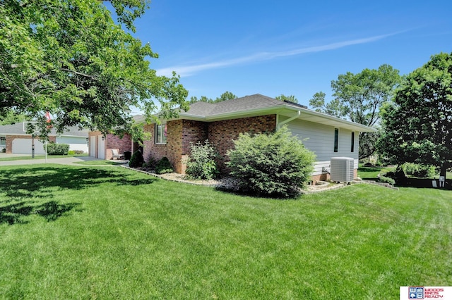 1714 S 14th Circle Dr, Beatrice, NE 68310 - ranch-style home with central air condition unit, a front lawn, brick siding, and a garage