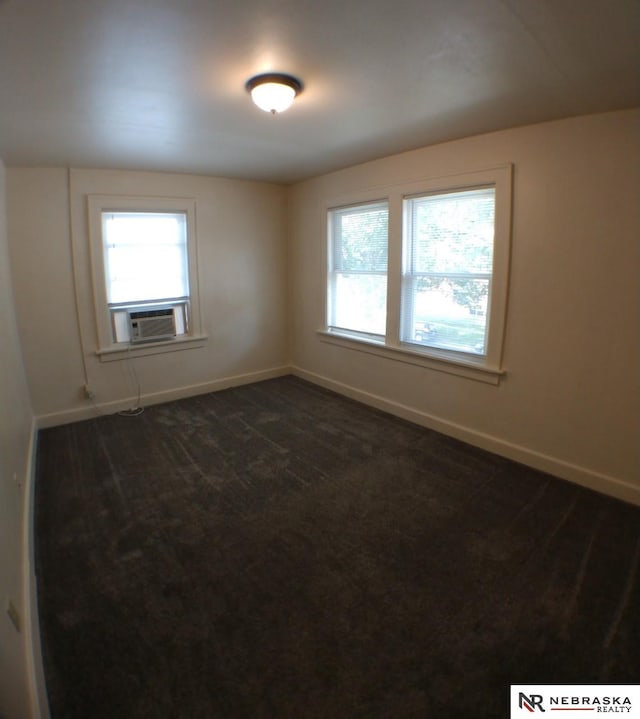 1941 J St, Lincoln, NE 68510 - unfurnished room featuring cooling unit, baseboards, and dark carpet