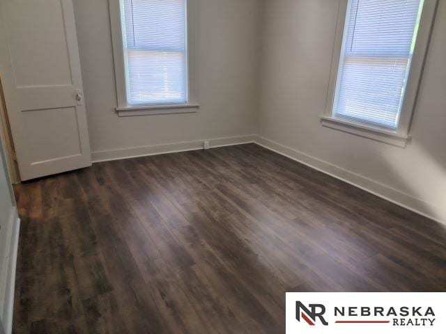 1941 J St, Lincoln, NE 68510 - spare room featuring baseboards and dark wood-type flooring