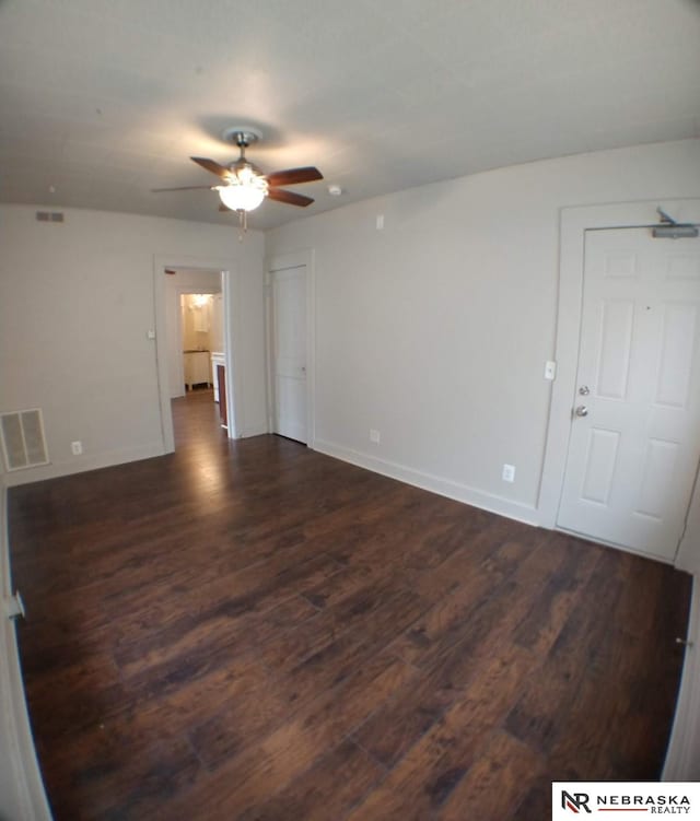 1941 J St, Lincoln, NE 68510 - unfurnished room with dark wood-style flooring, a ceiling fan, and baseboards