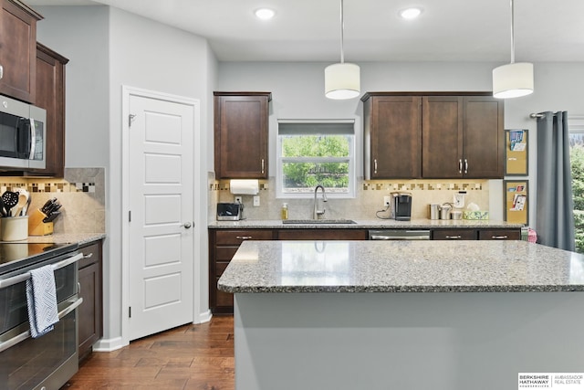 kitchen with stainless steel appliances, a sink, dark wood-style flooring, recessed lighting, and backsplash