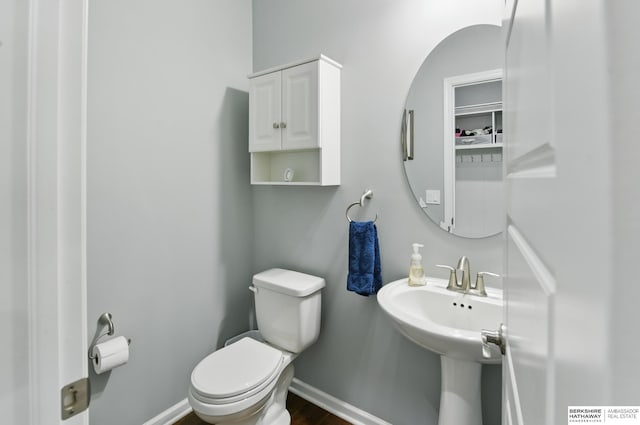 bathroom featuring toilet, baseboards, and wood finished floors