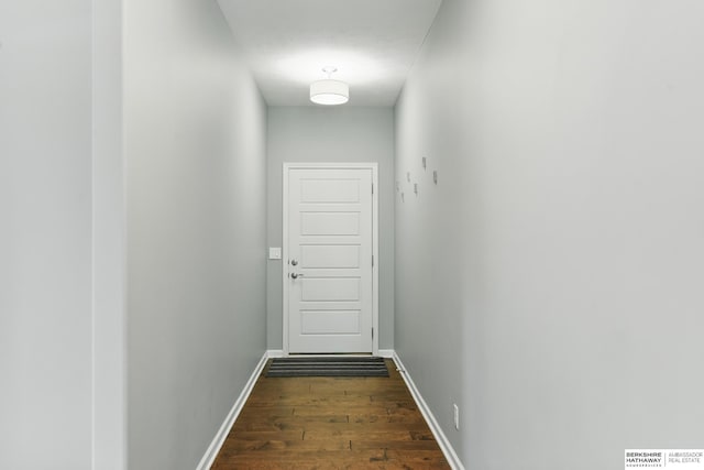 doorway to outside with dark wood-type flooring and baseboards