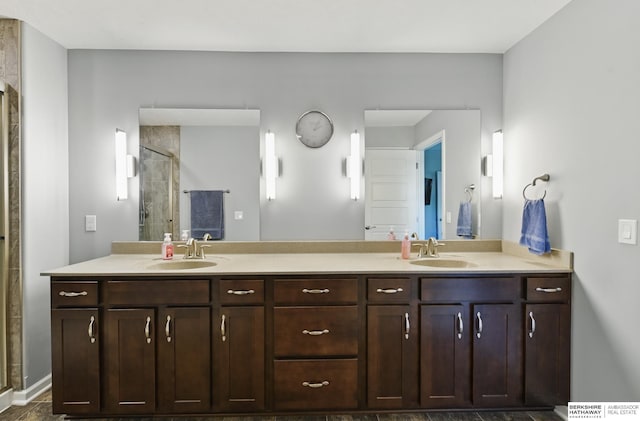 full bath with a stall shower and double vanity