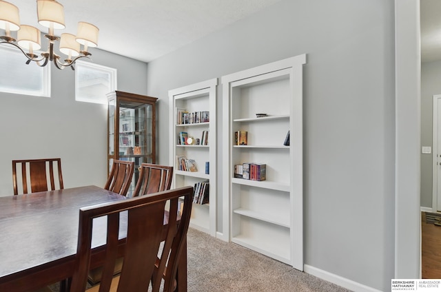carpeted dining room featuring a chandelier, baseboards, and built in features