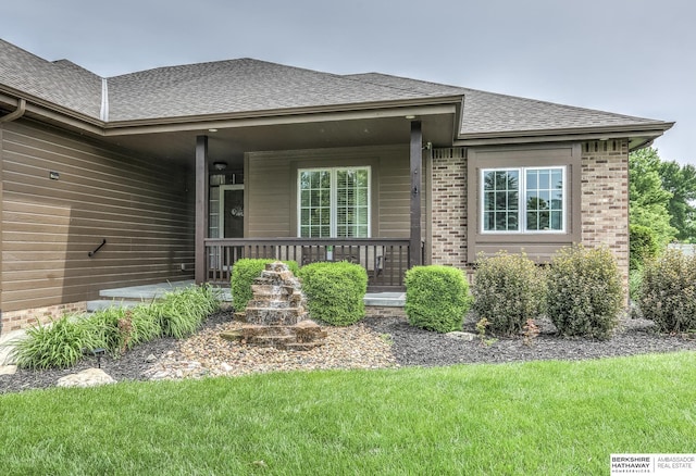 7309 S 196th Cir, Gretna, NE 68028 - view of front of house with covered porch, roof with shingles, a front lawn, and brick siding