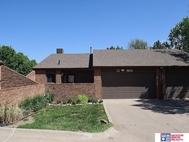 ranch-style house featuring brick siding, an attached garage, and concrete driveway