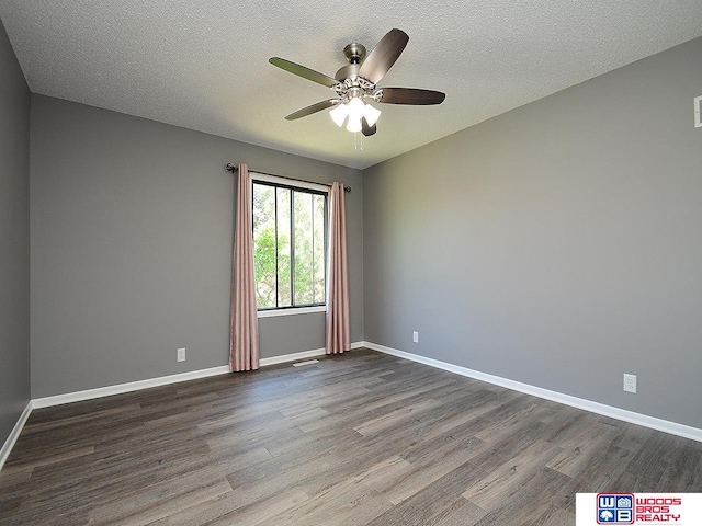 empty room featuring dark wood finished floors, a ceiling fan, baseboards, and a textured ceiling
