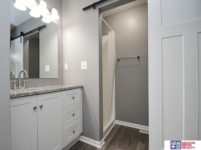 full bathroom featuring wood finished floors, vanity, baseboards, and curtained shower