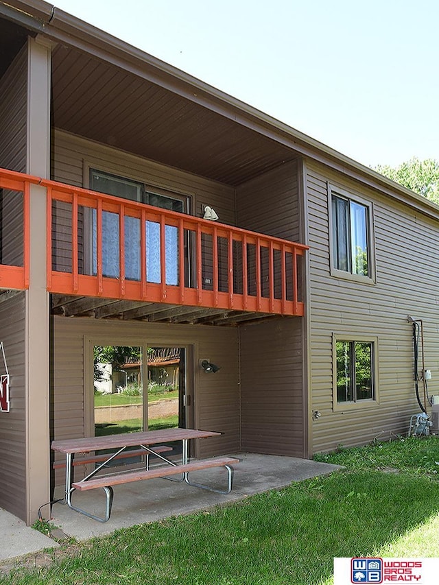 back of house featuring a patio and a lawn