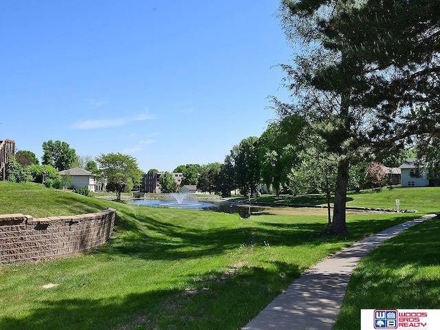 view of home's community featuring a water view and a yard