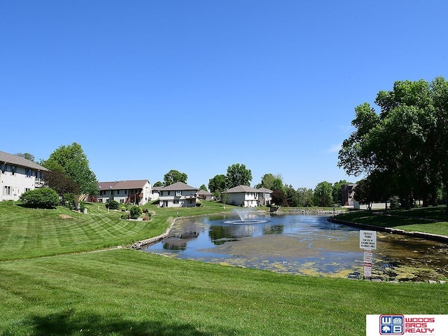 view of home's community with a water view and a yard