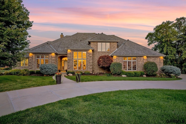 3835 S 179th Ter, Omaha, NE 68130 - french provincial home featuring a lawn, stone siding, and a chimney