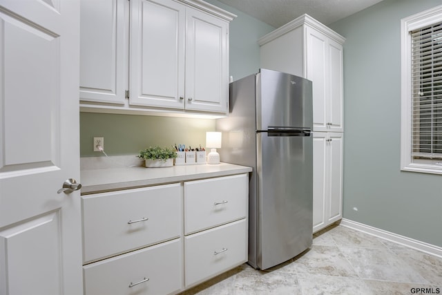 3835 S 179th Ter, Omaha, NE 68130 - kitchen with freestanding refrigerator, white cabinets, light countertops, and baseboards