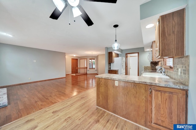 2727 N 75th St, Lincoln, NE 68507 - kitchen with white appliances, light wood-style floors, a peninsula, and light countertops
