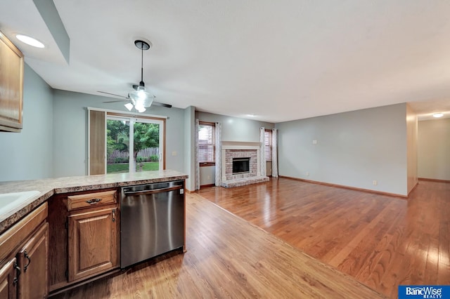 2727 N 75th St, Lincoln, NE 68507 - kitchen featuring dishwasher, a fireplace, a ceiling fan, and light wood-style floors