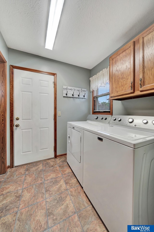2727 N 75th St, Lincoln, NE 68507 - laundry area featuring cabinet space, separate washer and dryer, light stone finish flooring, a textured ceiling, and baseboards