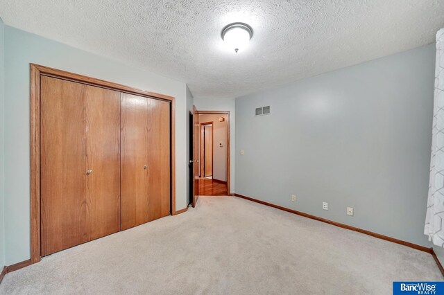 2727 N 75th St, Lincoln, NE 68507 - unfurnished bedroom featuring a closet, carpet flooring, a textured ceiling, and baseboards