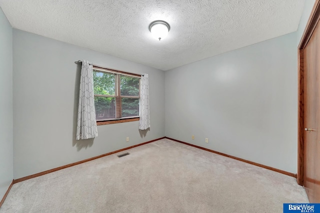 2727 N 75th St, Lincoln, NE 68507 - spare room featuring carpet, a textured ceiling, and baseboards
