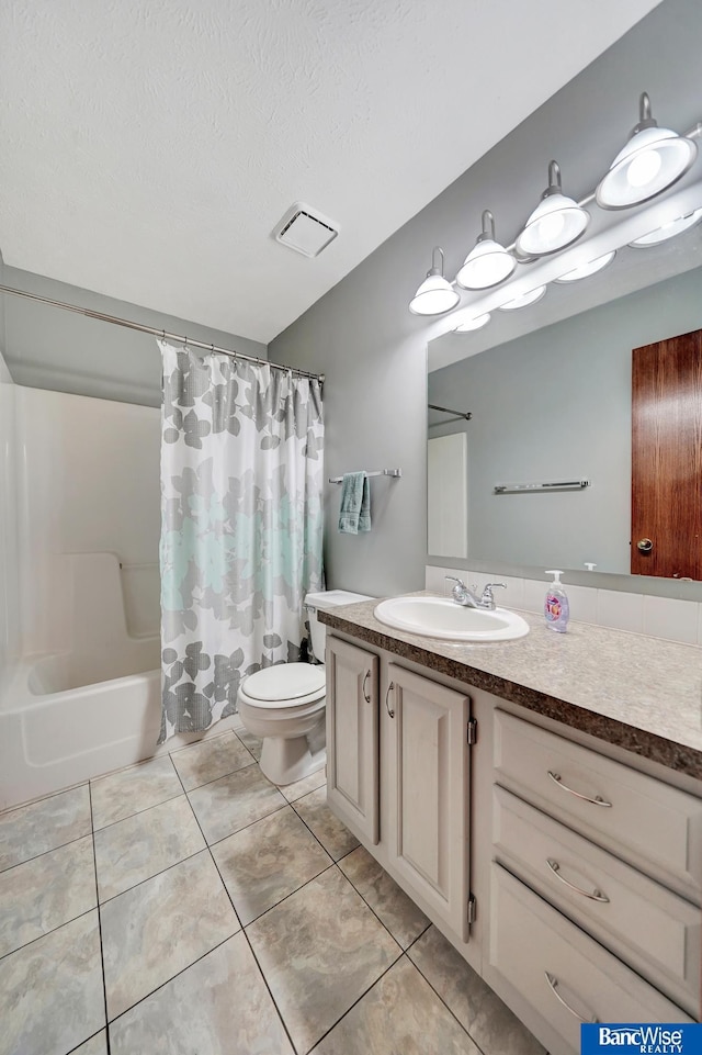 2727 N 75th St, Lincoln, NE 68507 - full bath with tile patterned flooring, toilet, vanity, shower / bath combo, and a textured ceiling