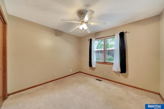 2727 N 75th St, Lincoln, NE 68507 - empty room featuring light colored carpet, baseboards, a ceiling fan, and a textured ceiling