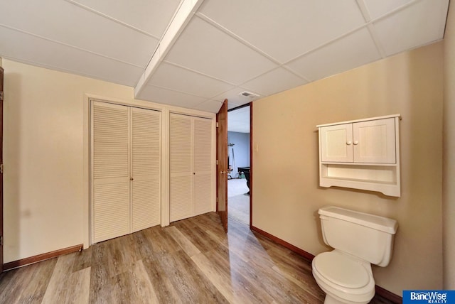 2727 N 75th St, Lincoln, NE 68507 - bathroom featuring wood finished floors, baseboards, a drop ceiling, and toilet