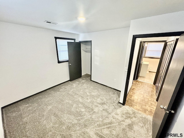 unfurnished bedroom featuring baseboards, a closet, and light colored carpet
