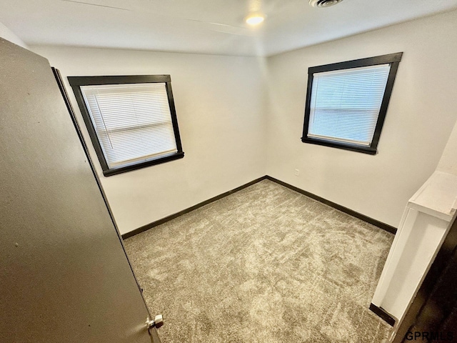 empty room featuring carpet flooring and baseboards