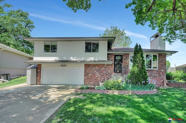 split level home with brick siding, an attached garage, driveway, and a front lawn