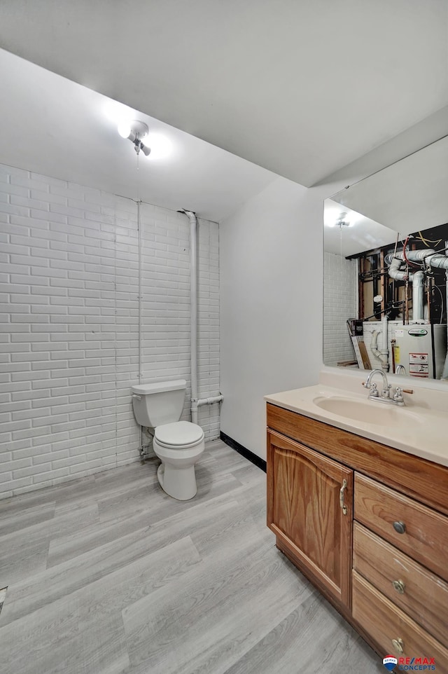 bathroom featuring wood finished floors, toilet, and vanity