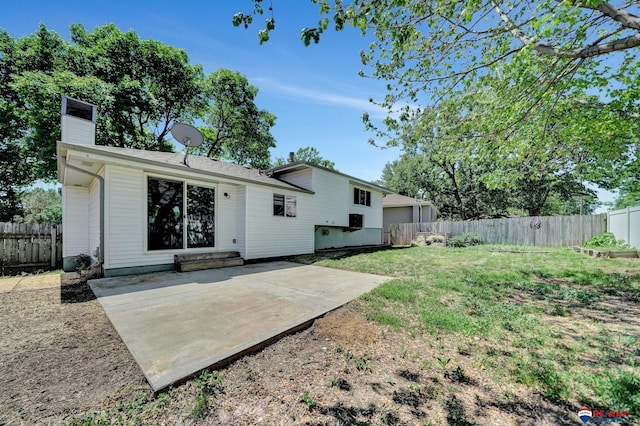 rear view of property with a fenced backyard, a chimney, and a patio area
