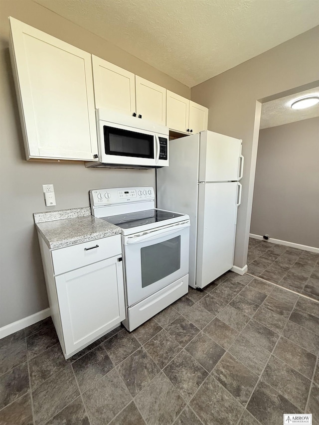4227 N 57th St, Lincoln, NE 68507 - kitchen featuring white appliances, baseboards, light countertops, white cabinets, and a textured ceiling